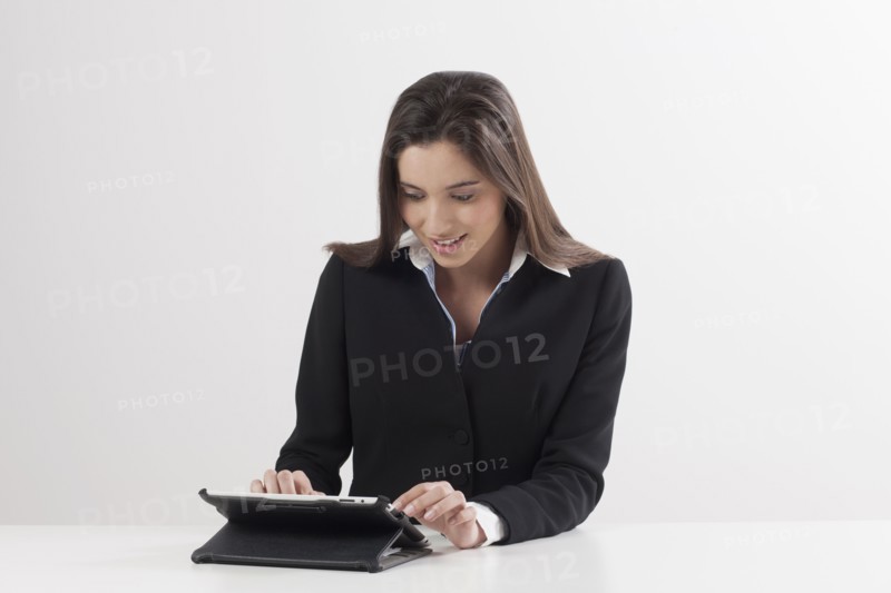 Smiling young woman using digital tablet. Photo : Jan Scherders