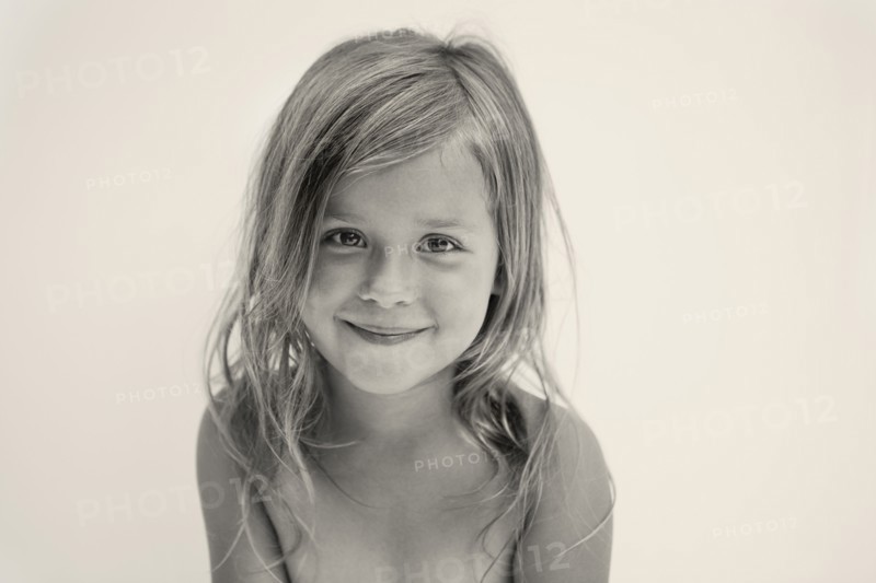 Portrait of smiling girl (6-7), studio shot. Photo : King Lawrence