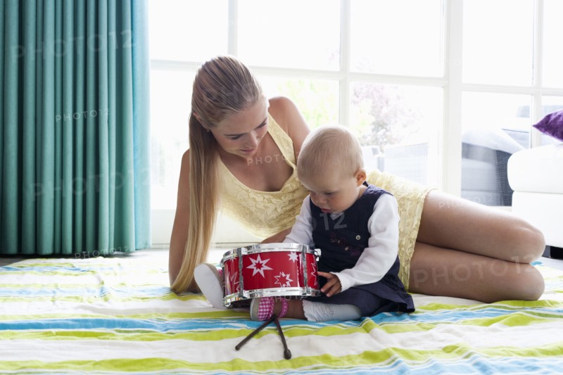 Young mother with daughter playing with drum. Photo: Mark de Leeuw
