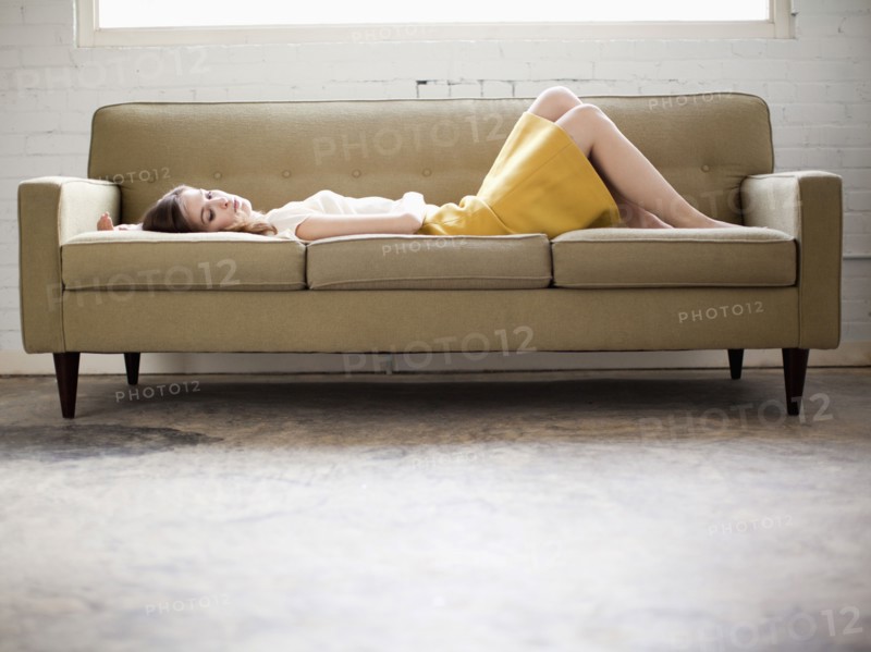 Young woman lying on sofa. Photo : Jessica Peterson