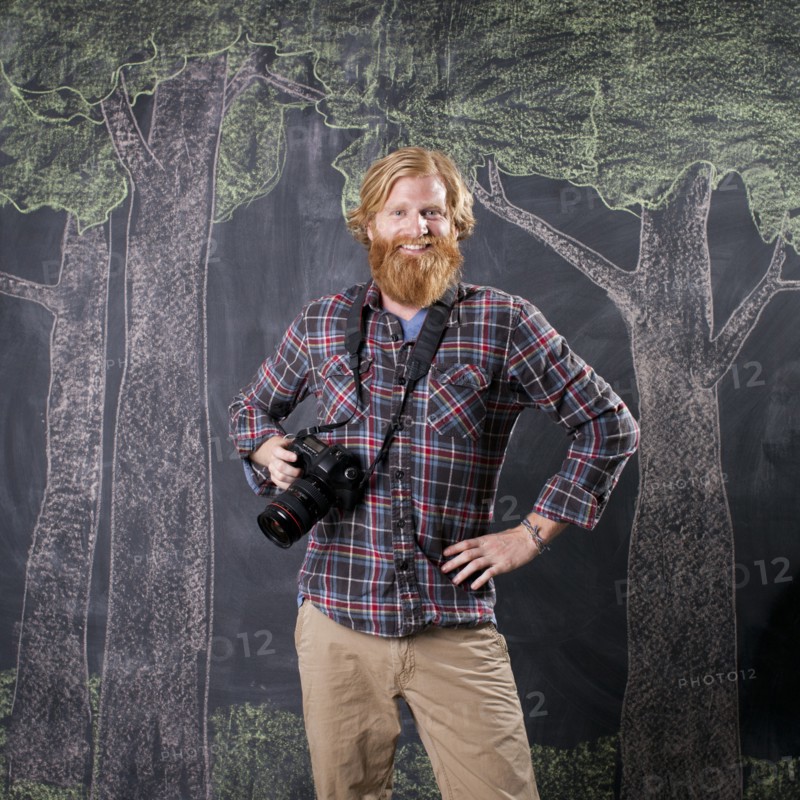 Man in front of blackboard taking pictures. Photo : Jessica Peterson