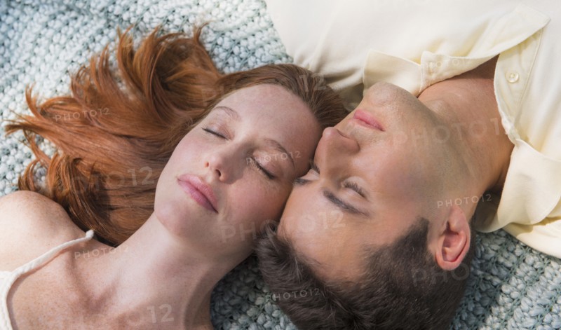 Portrait of couple lying on blanket. Photo : Tetra Images