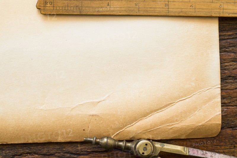 Old brown paper with ruler and compass, studio shot.