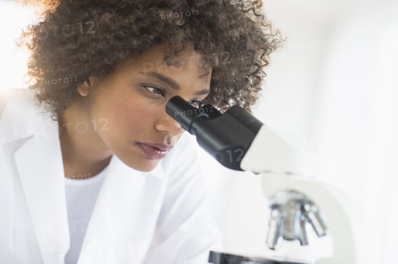 Woman using microscope in laboratory.