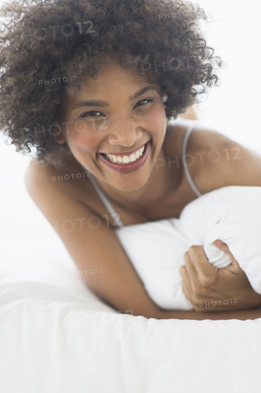 Portrait of woman lying on bed.