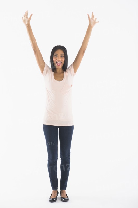 Portrait of woman with arms up, studio shot.