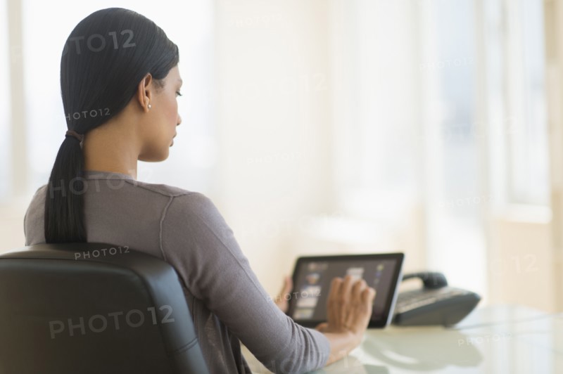 Businesswoman using digital tablet in office.