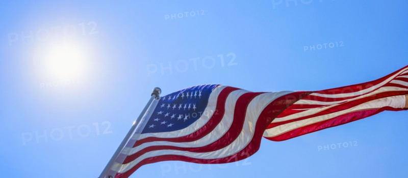 US flag against blue sky.