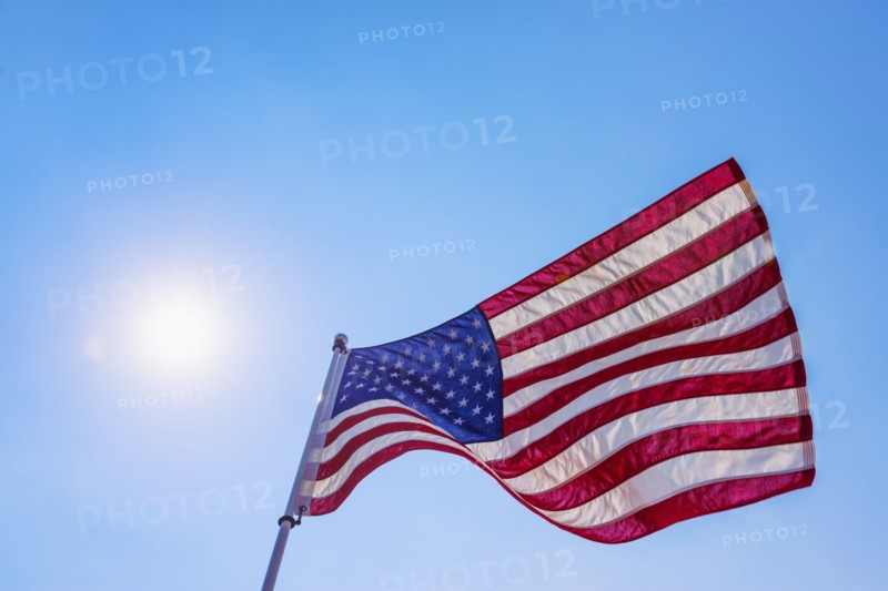 US flag against blue sky.
