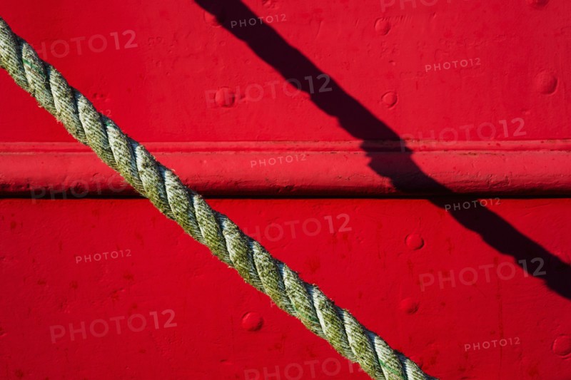 Detail of red tugboat with rope.