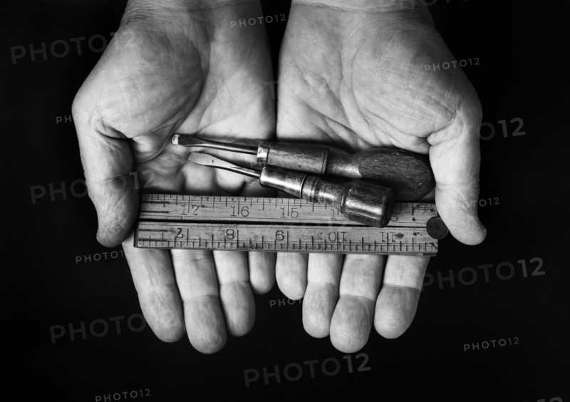 Studio shot of hands holding antique tools.