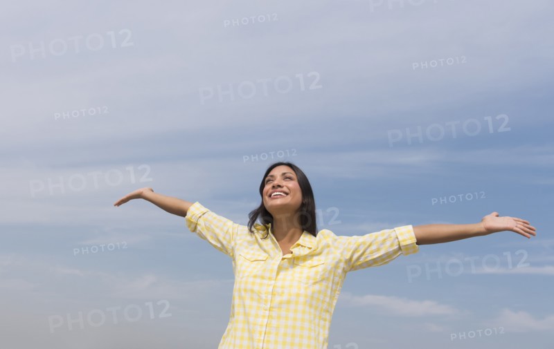 Happy woman against blue sky .