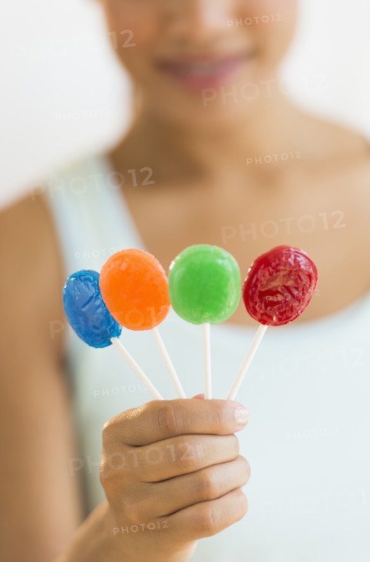Woman holding colorful lollypops.