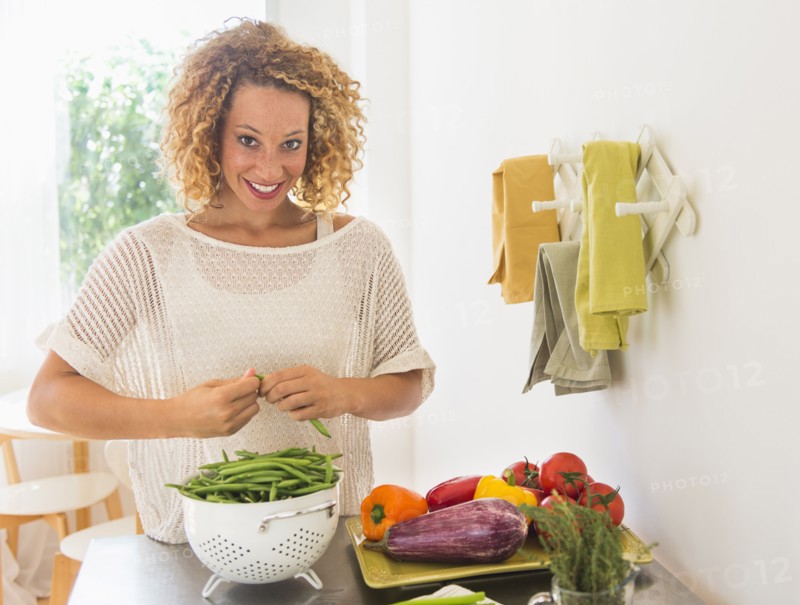 Young woman preparing food in kitchen.