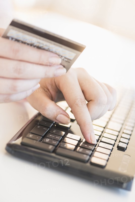 Close up of woman's hand doing online banking with laptop.