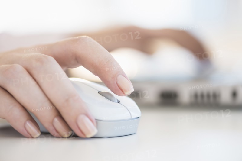 Close up of woman's hands using computer mouse.