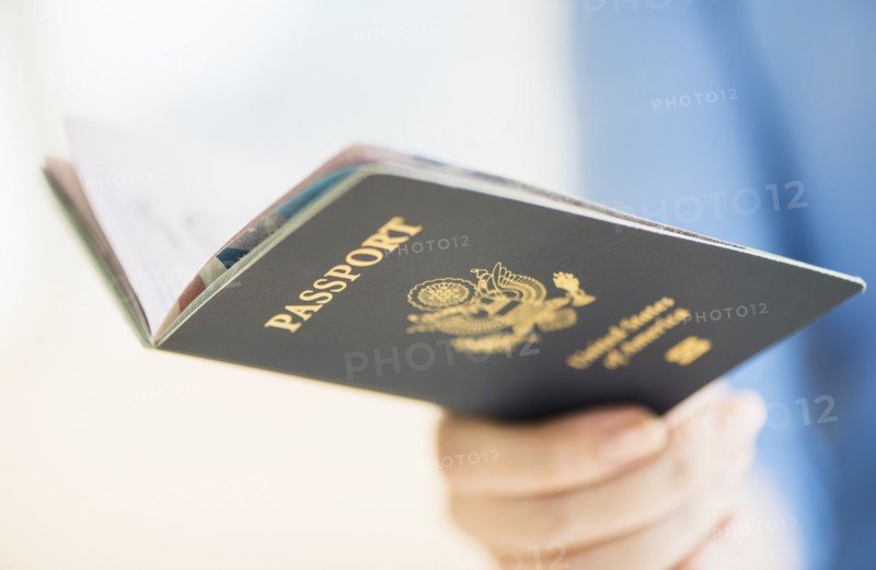 Close up of woman's hand holding open passport.