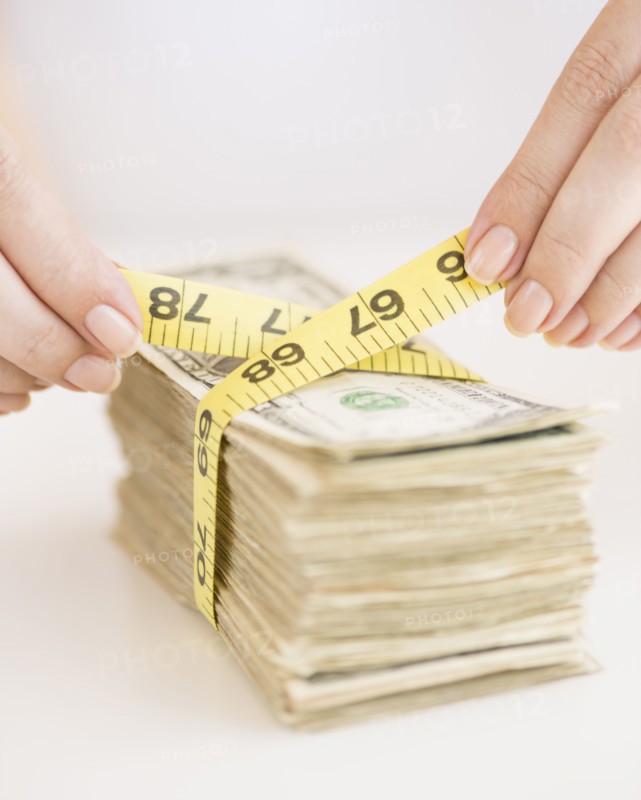 Woman measuring bunch of banknotes.