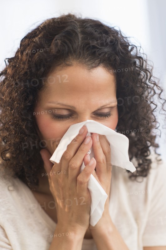 Portrait of woman blowing nose.