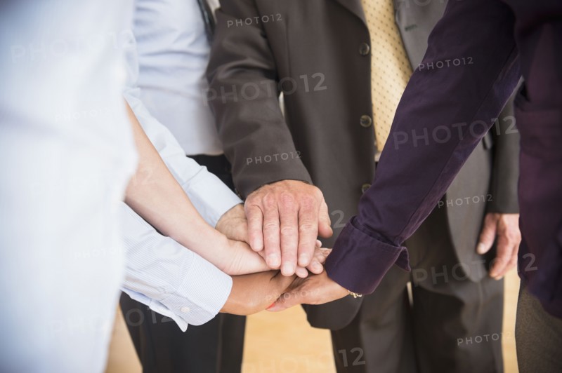 Office workers holding hands. Photo : Jamie Grill