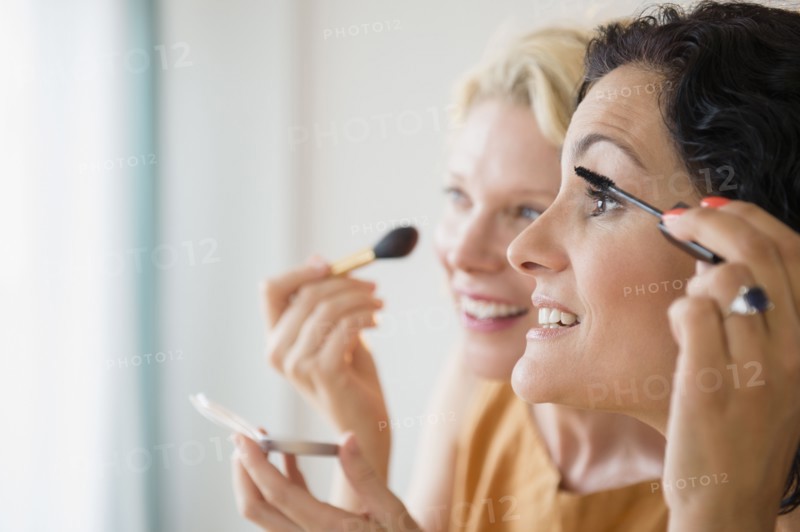 Female friends during applying make-up. Photo : Jamie Grill