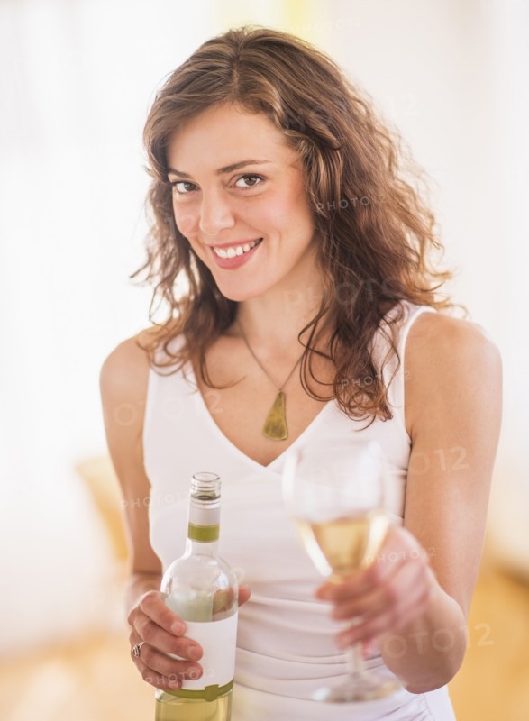 Woman holding wine bottle and glass. Photo : Daniel Grill