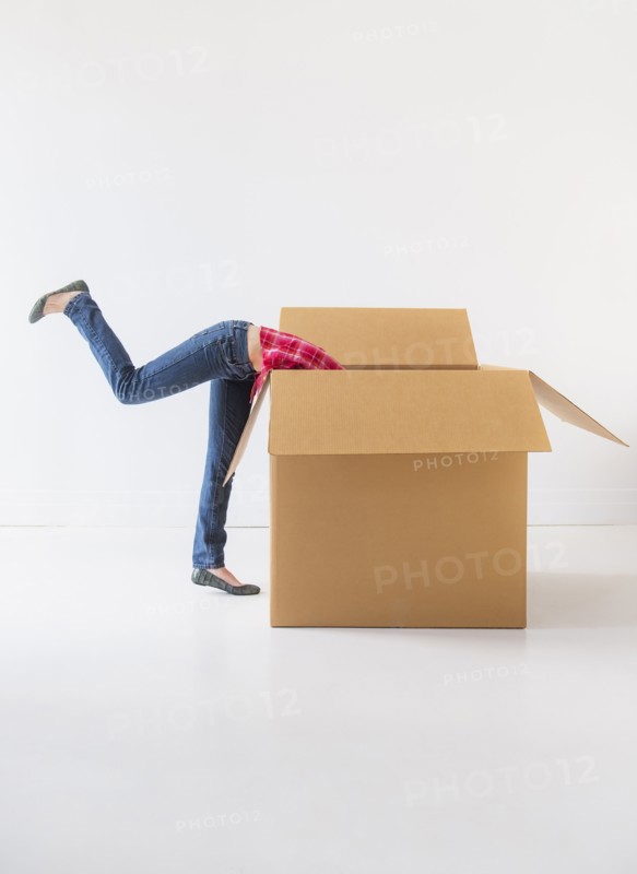 Studio shot of young woman looking into box. Photo: Daniel Grill