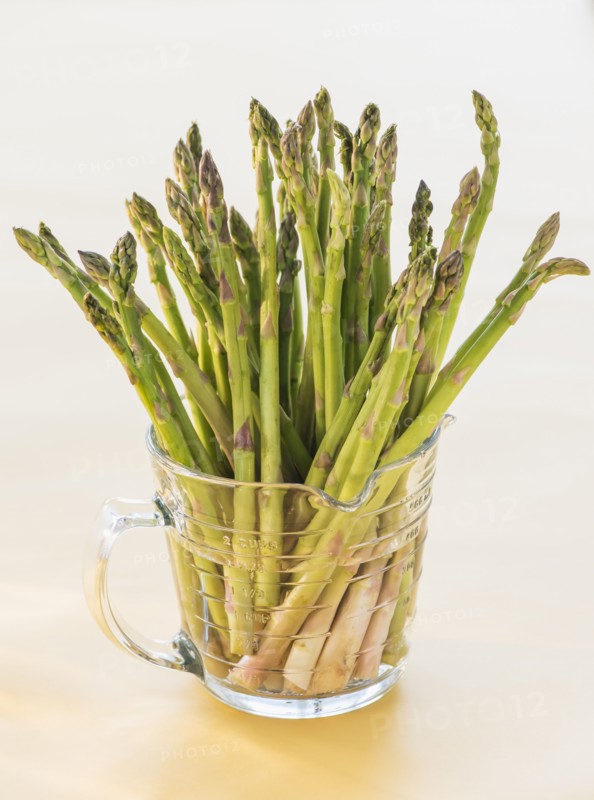 Bunch of asparagus in glass, studio shot. Photo : Daniel Grill