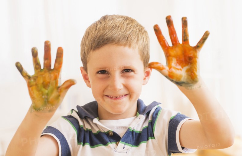 Young boy (6-7) showing hands stained with paint. Photo: Daniel Grill