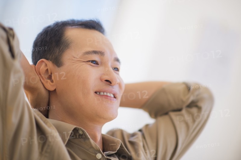 Profile of happy mid adult man with hands behind his back. Photo : Daniel Grill