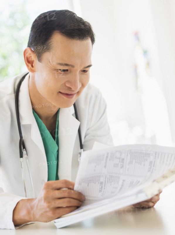 Doctor examining medical records. Photo : Daniel Grill