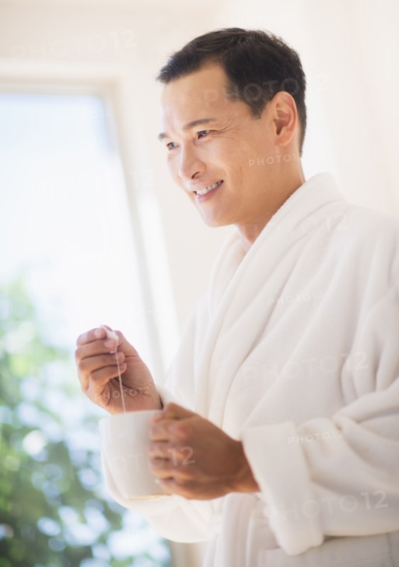 Mid adult man mixing herbal tea. Photo: Daniel Grill