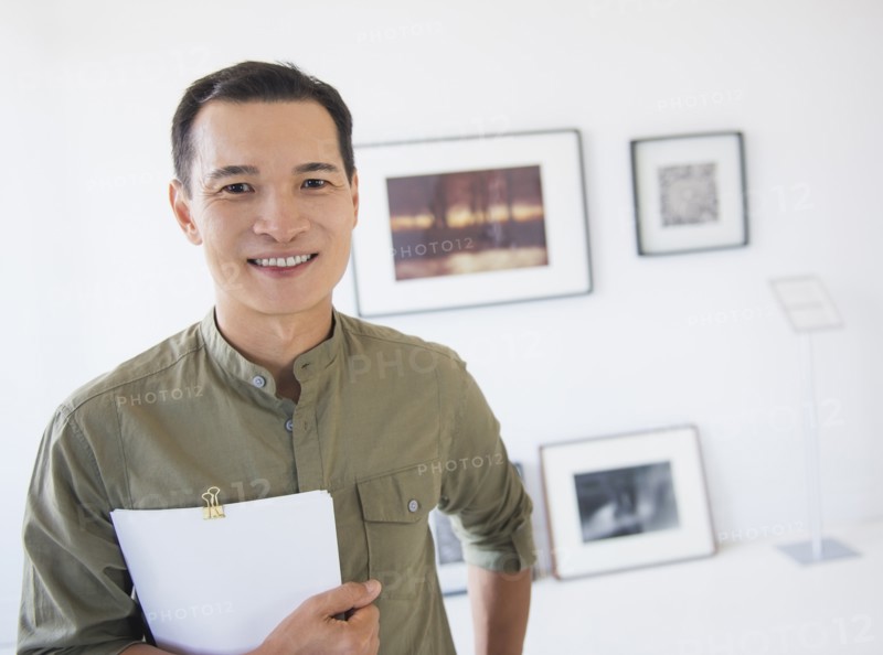 Gallery worker posing in front of newly hanged paintings. Photo: Daniel Grill