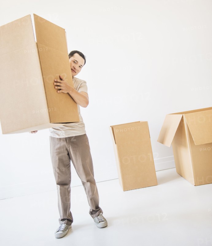 Mid adult moving cardboard boxes. Photo: Daniel Grill
