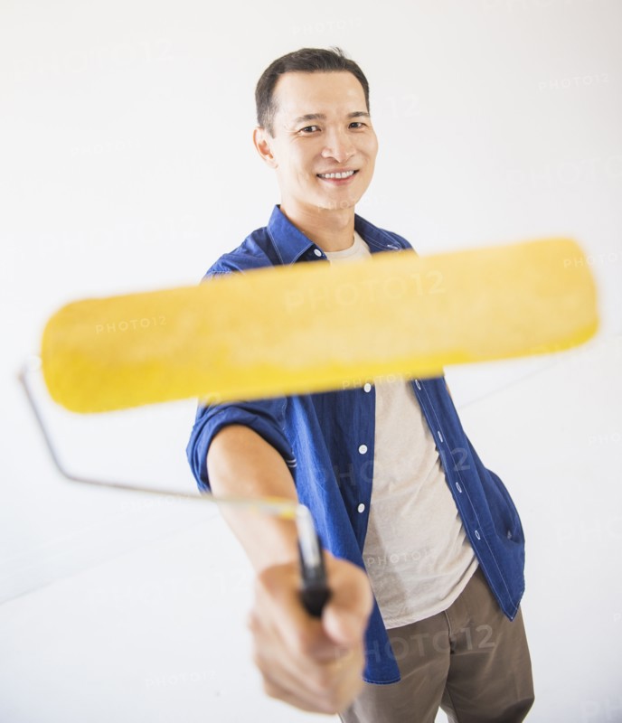 Man holding painting roll. Photo : Daniel Grill