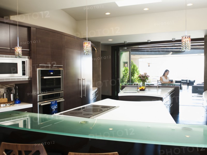 Young woman bustling around in modern domestic kitchen.