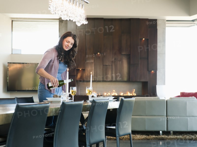 Young attractive woman pouring champagne into glasses. Photo: Erik Isakson