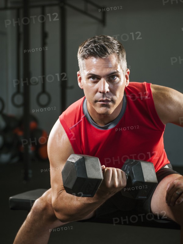 Mature man exercising with dumbbells.