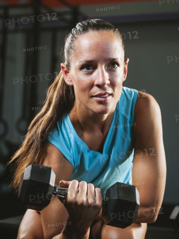Mid adult woman exercising with dumbbells.