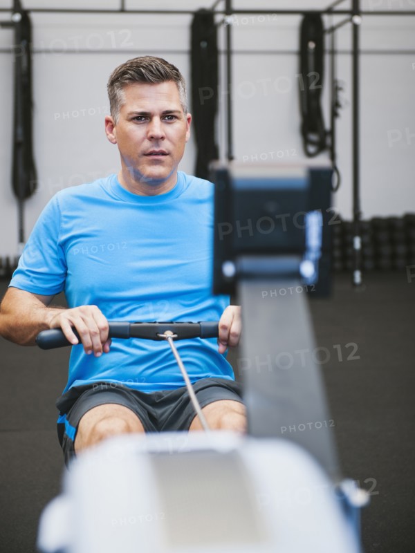 Mature man exercising on row machine in gym. Photo: Erik Isakson
