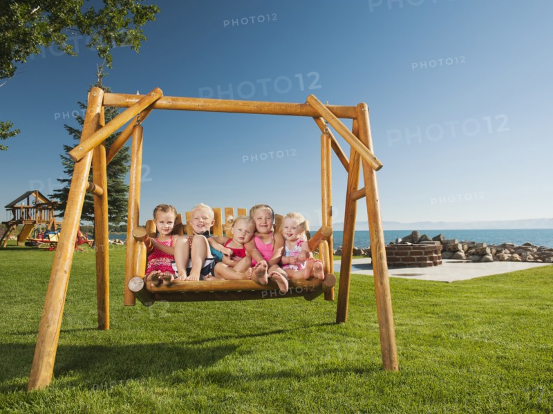 Portrait of children (2-3, 4-5) swinging.