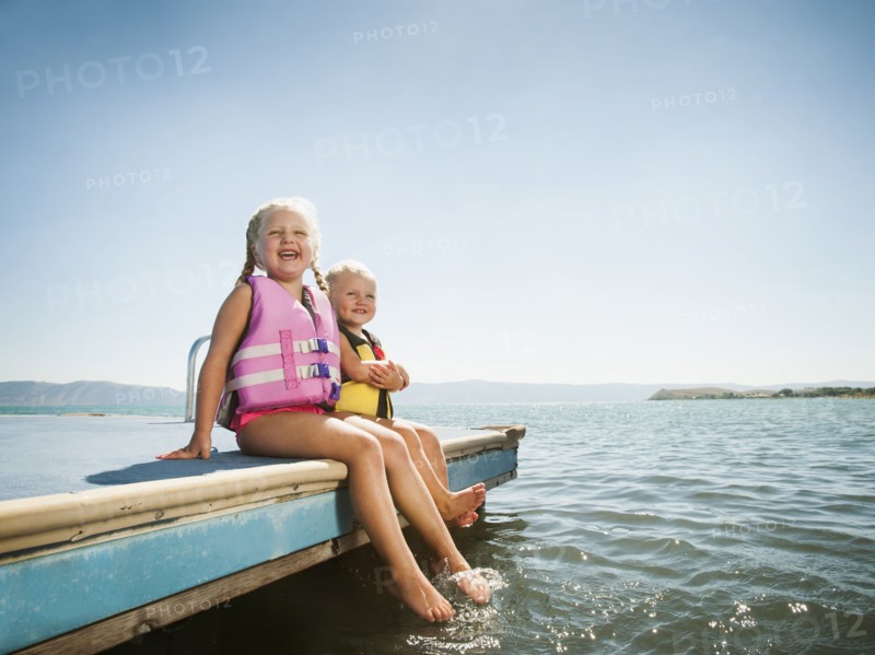 Girls (2-3, 4-5) sitting at the edge of raft in life jackets. Photo: Erik Isakson