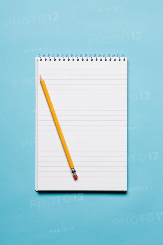 Single yellow sharpened pencil with blank stenographer notebook on blue background. Photo: Kristin Duvall