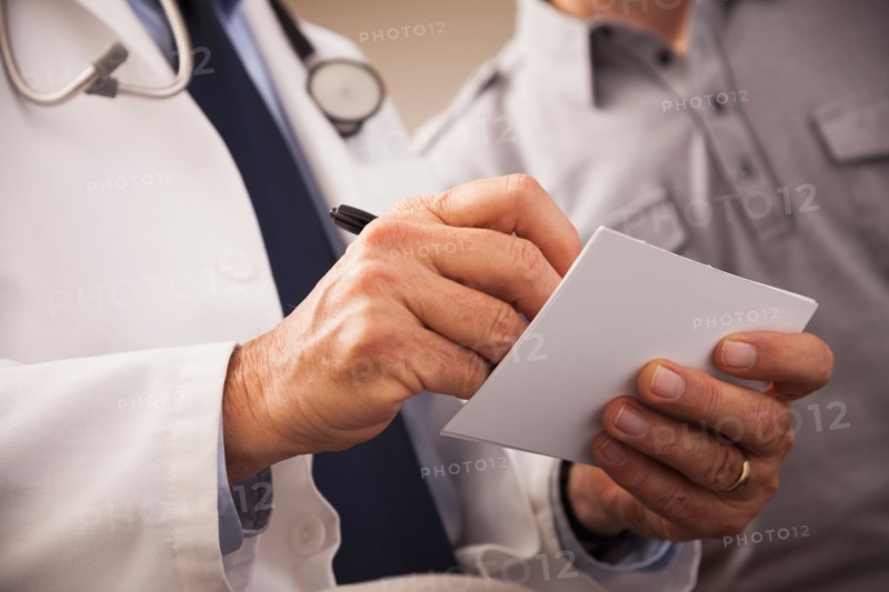 Close-up of doctor writing prescription for patient. Photo: Mike Kemp