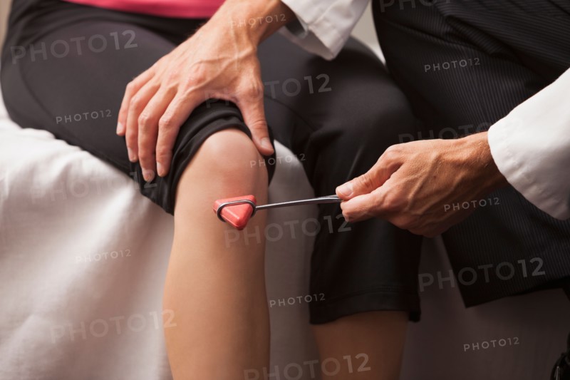 Close-up of doctor checking knee reflexes. Photo : Mike Kemp