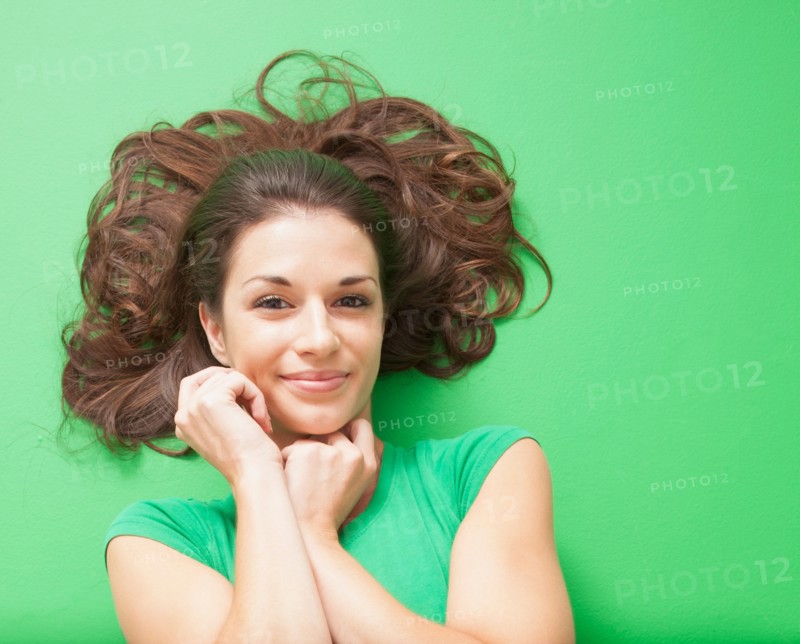 Beauty shot of girl laying on green background. Photo : Mike Kemp