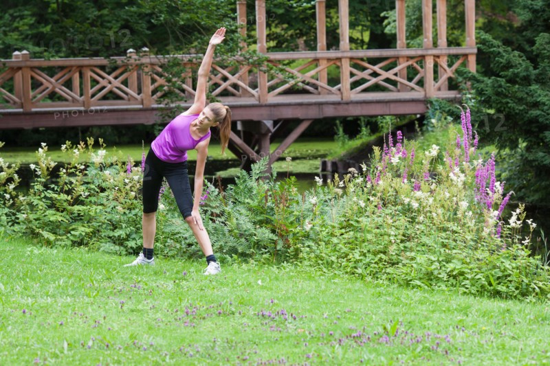 Young woman stretching her upper body in a field