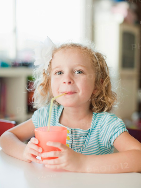 Portrait of girl drinking through straw. Photo : Jessica Peterson