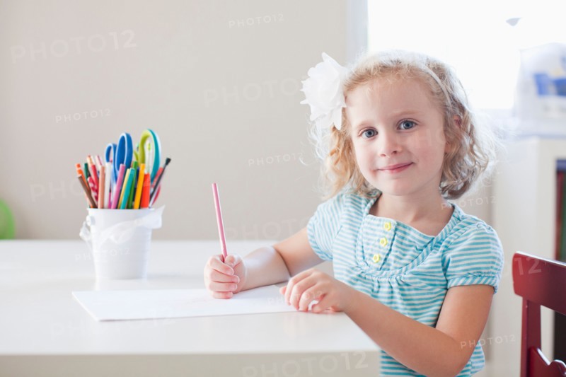 Girl sitting at table and looking at camera. Photo: Jessica Peterson