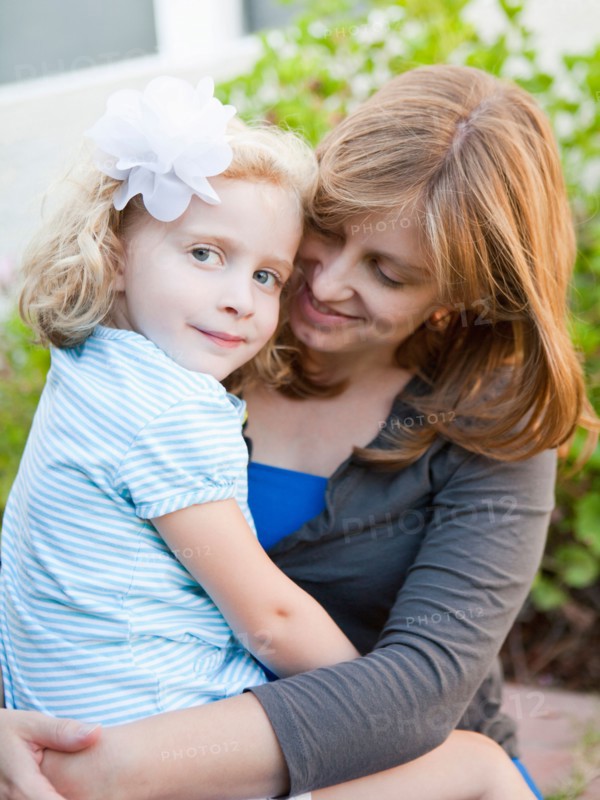 Portrait of mother and her daughter sitting on her lap. Photo : Jessica Peterson